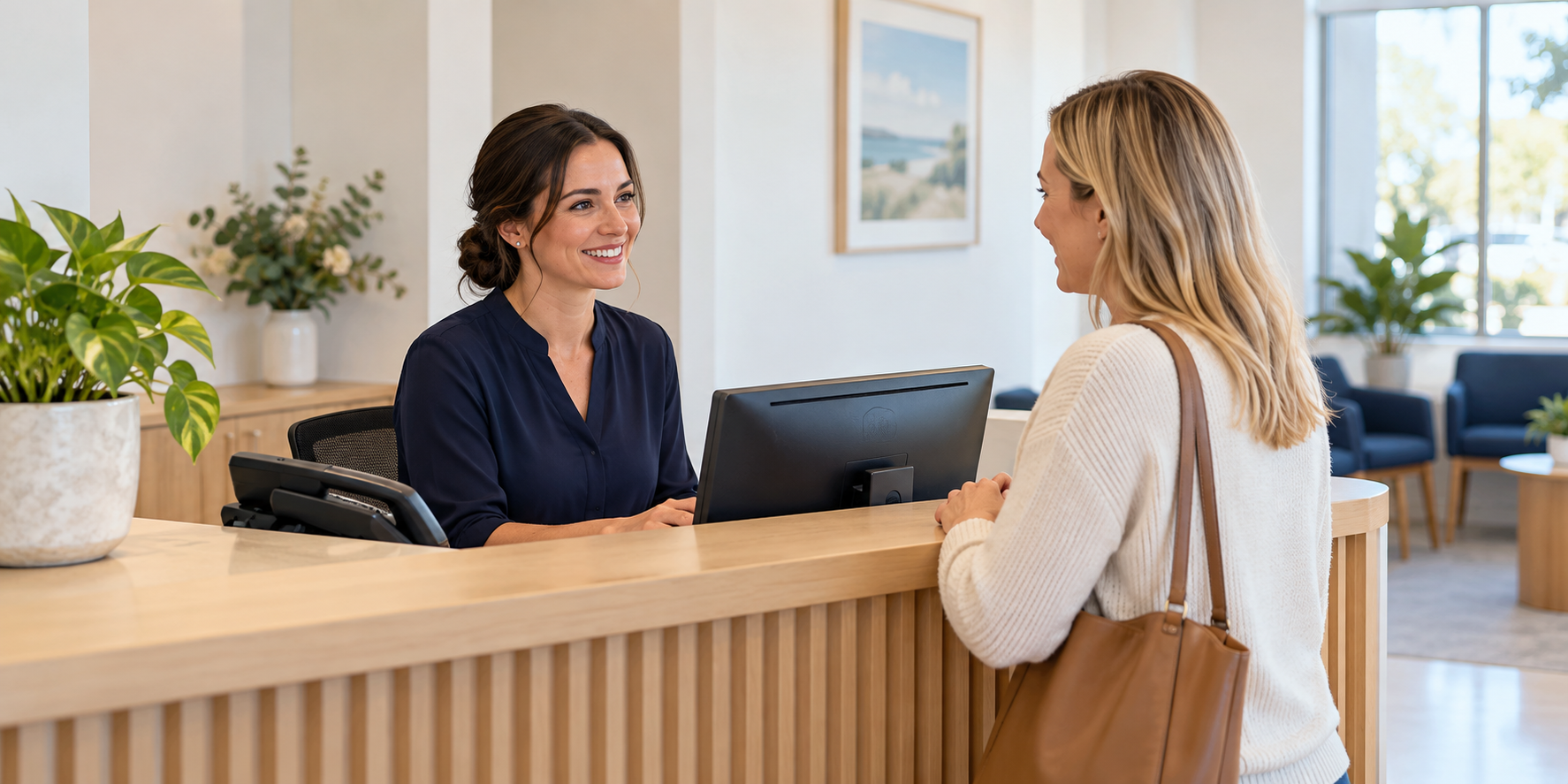 A receptionist welcomes a visitor at a medical clinic.